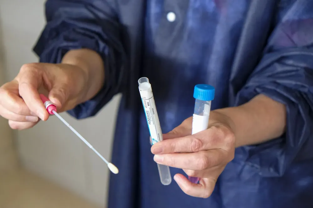 Woman holding a self-PCR COVID-19 test